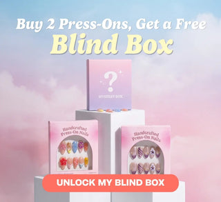 Handcrafted press-on nail gift boxes displayed on white podiums with a mystery blind box against a pastel cloud background.