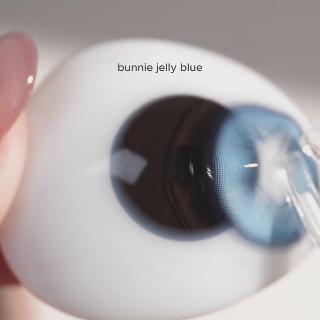 EyeCandys contact lenses try-on video on fake eyeball featuring Frosted Eye Set, Bunnie Jelly Blue, Bunnie Milky Ash Grey, Doe Golden Brown, and Doe Blue colored contacts with natural enlargement and detailed color comparison