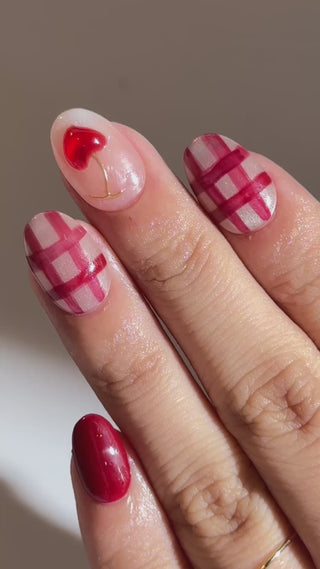 Hand close-up showcasing EyeCandys Very Cherry press on nails