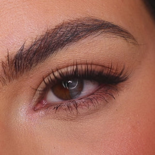 Model wearing EyeCandys Desire Grey colored contact lenses, showcasing a soft grey eye transformation with close-up views, natural movement, and a natural-looking cool-toned effect on brown eyes.