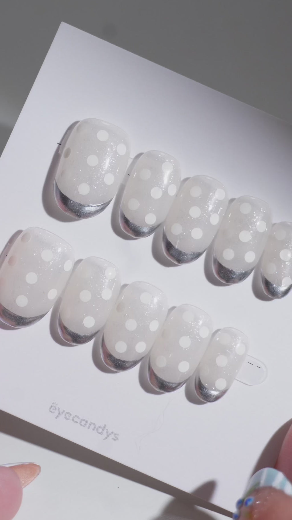Wearing EyeCandys Silver Spotted Press-On Nails — warm nude base with white polka dots and chrome silver French tips, short and round shape