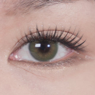 Close-up video of eye with long lashes wearing Eyecandys Cashmere Satin Olive prescription colored contact lens, showcasing natural olive tone, lens design, and comfortable fit.