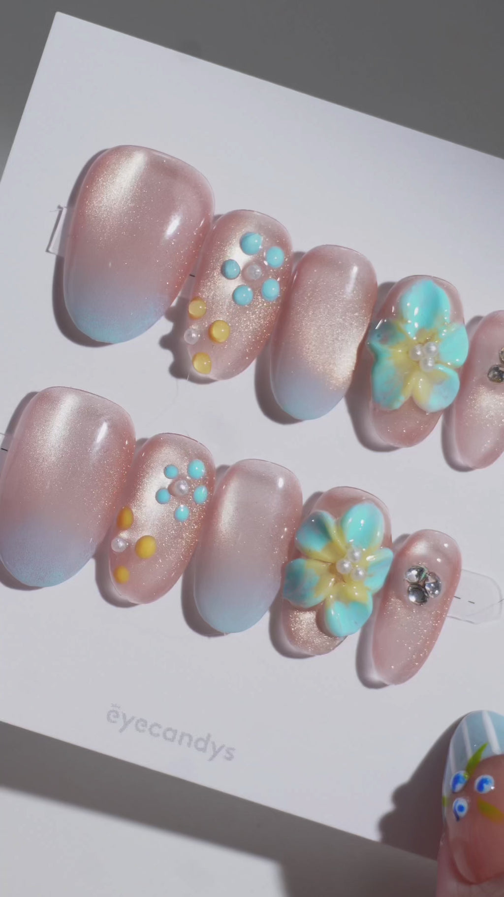 Wearing EyeCandys Lei'd Back Press-On Nails — sheer nude to gold shimmer to baby blue gradient with sculpted 3D plumeria flower accents, almond shape