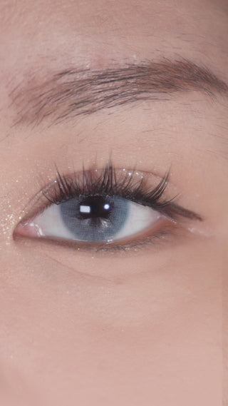 Long-lashed eyes blinking to reveal EyeCandys Glossy Blue prescription colored contact lenses