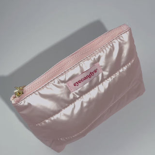 EyeCandys Puffy Essentials Pouch in pearlescent pink with quilted design and branded tag — perfect for storing makeup, contact lens kits, or glasses; stylish, wipeable, and travel-friendly.
