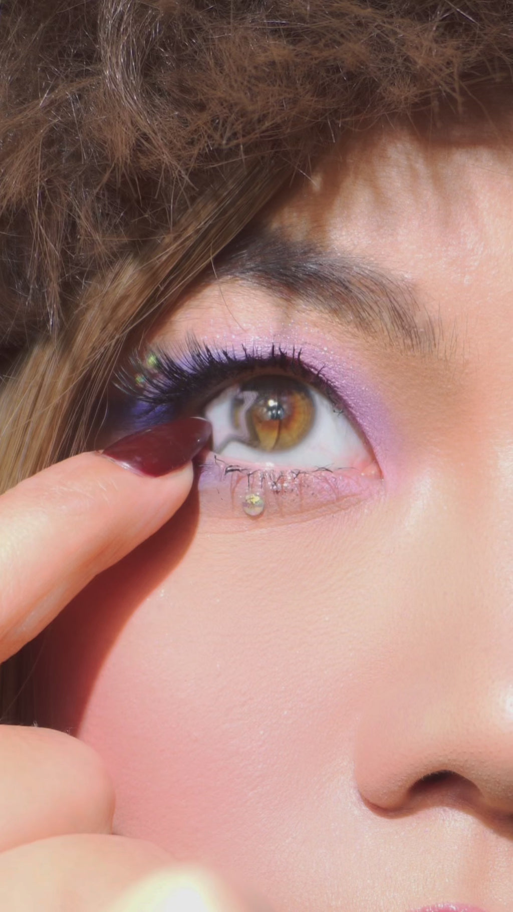 Model wearing EyeCandys Pink Star colored contact lens, close-up of eye with long lashes, showing a soft pink hue, natural blending, subtle eye enlargement, and a bright, enchanting look perfect for everyday wear or special occasions.