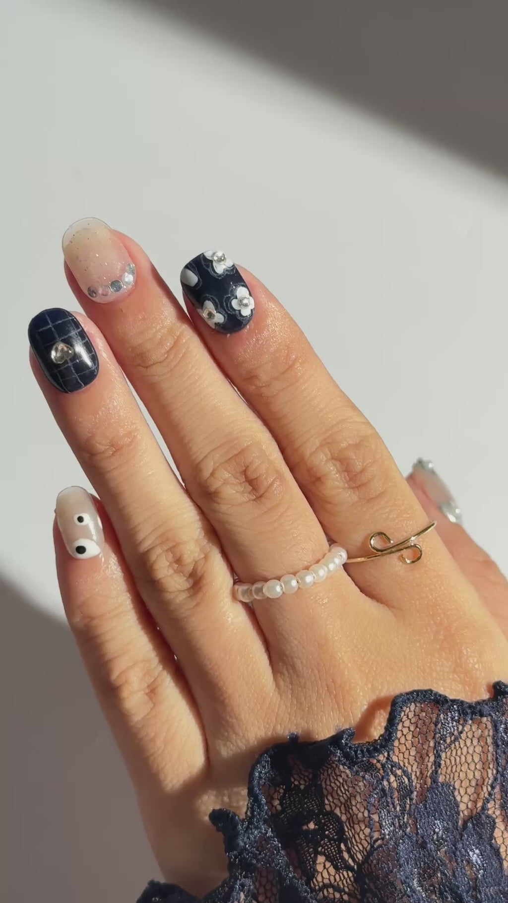 Lifestyle close-up of hand wearing EyeCandys All Tied Up press on nails