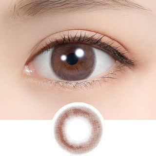 A close-up of a brown eye with long lashes wearing Feliamo 1-Day Sakura Mousse (10pk) color contact lenses for a natural look. Below, a circular image displays the detailed lens design by Feliamo.