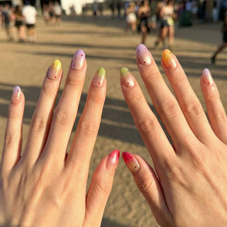 Close up hand showcasing Sorbet Season press on nails with colorful gradient tones and scattered confetti nail art.