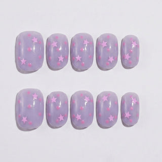 Short round press on nails EyeCandys Stardust Baby with lilac jelly base, scattered star sequins, and pink confetti dots.
