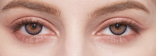 Close-up of a person's face highlighting their hazel eyes, well-groomed eyebrows, and natural makeup, enhanced by NEO Vision Cosmo Violet coloured contact lenses from NEO Vision.